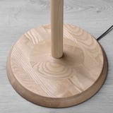 Base tonda in legno di frassino della lampada KINNAHULT, liscia, venatura del legno chiaro a vista.