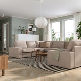Soggiorno moderno con divano beige KIVIK, tappeto a righe, lampada a sospensione e tavolino della metà del secolo. Il divano è grande, può ospitare più posti.
