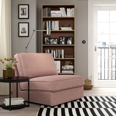 Divano letto rosa KIVIK in accogliente zona giorno con libreria e tappeto. In alternativa, divano letto KIVIK rosa in piccolo soggiorno con libreria e tappeto.