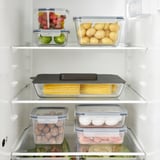 Ripiano del frigorifero ben organizzato, che mostra le verdure in contenitori, piatto coperto, contenitori sigillati.