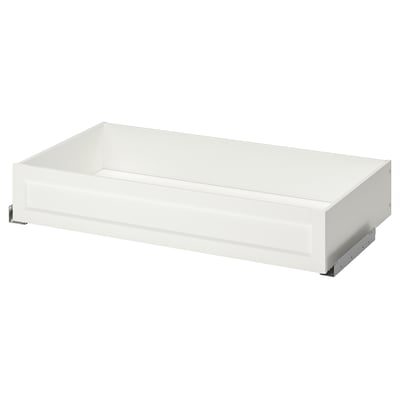 Un cassetto bianco con cornice KOMPLEMENT. È rettangolare con una superficie liscia e piana. Il cassetto è progettato per l'uso in un sistema di armadi pax.