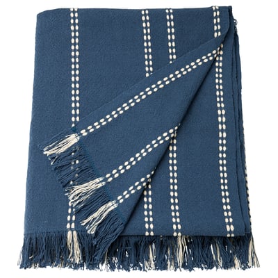 Plaid piegato in cotone blu con righe bianche e frange.