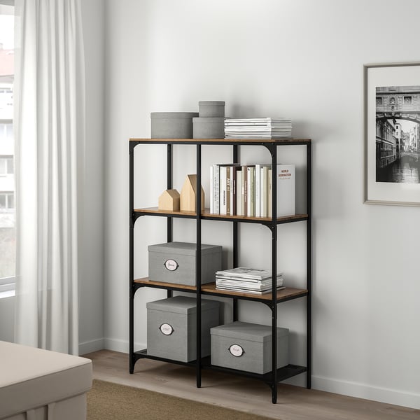 Libreria moderna KVARNVIK con metallo nero, legno, tessuti, libri e decorazioni.