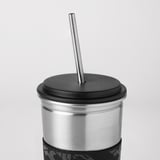 Un bicchiere in metallo con coperchio in gomma e cannuccia, che mette in mostra materiali di alta qualità e un design elegante.