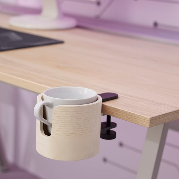 Portatazze in legno su scrivania con tazza bianca.