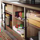 Porta tv in legno con maniglie in metallo nero e ante in vetro, per riporre elettronica e forniture per ufficio.