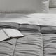 Piumone grigio LÅSBRÄKEN sul letto con libro bianco, morbido e accogliente, materiali riciclati.