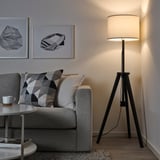 Accogliente soggiorno con divano grigio, cuscini geometrici e lampada LAUTERS. Due opere d'arte astratte sopra il divano.