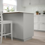 Moderna isola cucina grigia con sedie bianche, design elegante.