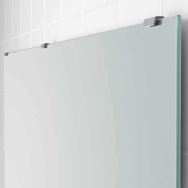 Piccolo specchio da bagno montato a parete con pellicola antisfondamento, trattenuto da 2 robuste clip.