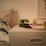 Un trenino giocattolo per bambini su un cassetto. Il treno ha un pulsante sulla parte superiore per il controllo, le luci e può fare retromarcia.