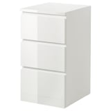 Una cassettiera MALM bianca con tre cassetti. È elegante, moderno, con una finitura lucida e realizzato in truciolare e fibra di legno.