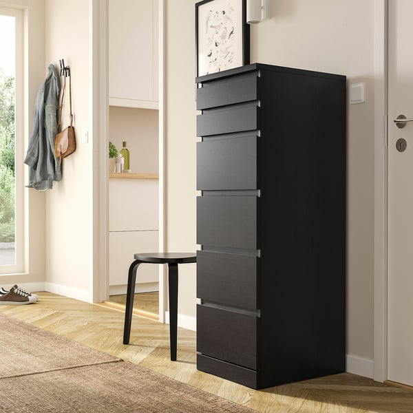 Ingresso moderno con cassettiera MALM nera. Design alto ed elegante con sei cassetti, più piccolo dell'armadio vicino, posizionato accanto alla porta.
