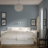 Moderna camera da letto blu con letto MALM, comodini, arte minimalista e lampada a sospensione.