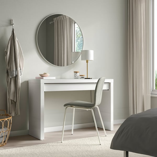 Camera da letto moderna con toletta MALM, specchio, sedia e lampada. Finestra con tenda, copriletto grigio.