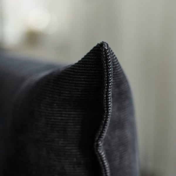 Tessuto nero ravvicinato, che mette in risalto texture e cuciture di alta qualità.