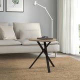 Tavolino moderno marriedamm con piano in legno chiaro e gambe in metallo scuro accanto al divano bianco.