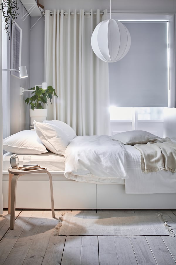 Camera da letto minimalista con tende, letto e tavolino bianchi MERETE. Pianta.