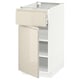 Un moderno mobile da cucina METOD bianco con cassetto e anta beige lucido, dotato di eleganti maniglie integrate.