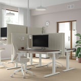 Ufficio moderno con schermo acustico MITTZON su scrivania regolabile, design minimalista, luci a sospensione, ampia finestra.