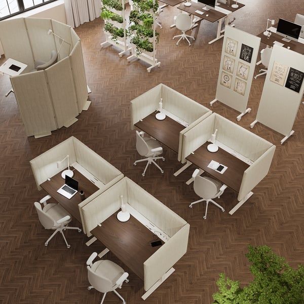 Ufficio moderno con schermi MITTZON, scrivanie, sedie, piante, luce naturale.
