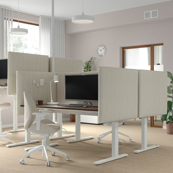 Ufficio moderno con scrivanie sit/stand MITTZON, monitor, sedie, schermi acustici e piante.