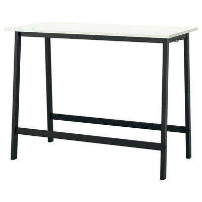 Il tavolo MITTZON ha un piano bianco, eleganti gambe in metallo nero e un design minimalista. Ideale per sedersi o stare in piedi, offre un'atmosfera moderna e funzionale.