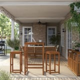 Patio esterno con tavolo, sgabelli e panca in legno marrone NÄMMARÖ, ideale per pranzare o lavorare.