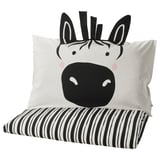 Simpatico cuscino zebrato su cuscino a righe bianco-nere, morbido, biancheria da letto per bambini.