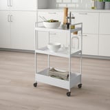 Carrello in metallo NISSAFORS con 3 ripiani in cucina per insalata, piatti, bicchieri e asciugamani.