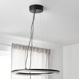 Moderna lampada a sospensione con anelli regolabili appesa al soffitto, controllata da telecomando.