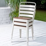 Sedia in metallo bianco con seduta in legno, adatta per mangiare all'aperto. Fa parte della collezione NORRMANSÖ.