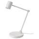 Una lampada da tavolo NYMÅNE bianca con braccio regolabile e caricatore wireless sulla base.