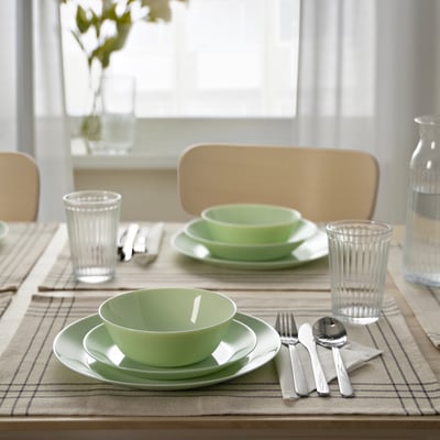 Stoviglie in vetro verde OFTAST con piatti e ciotole moderne su runner.