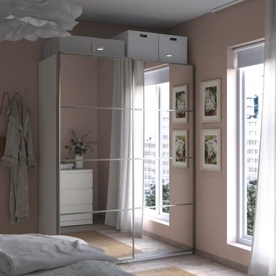 Camera da letto moderna con armadio PAX a specchio, ampia finestra e letto accogliente.