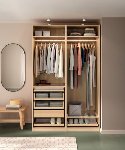 Armadio in legno con vestiti, specchio e tappeto.
