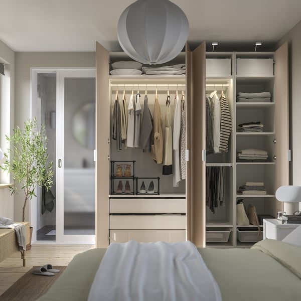 Camera da letto moderna con ampio armadio PAX con portaabiti, mensole e illuminazione integrata.