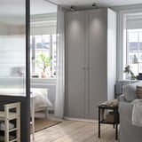 Camera da letto moderna con armadio PAX grigio alto, scrivania e divano grigio.