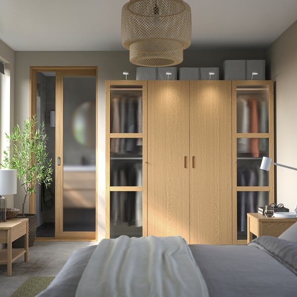 Camera da letto moderna con grande armadio PAX, accenti grigi, lampada in bambù.