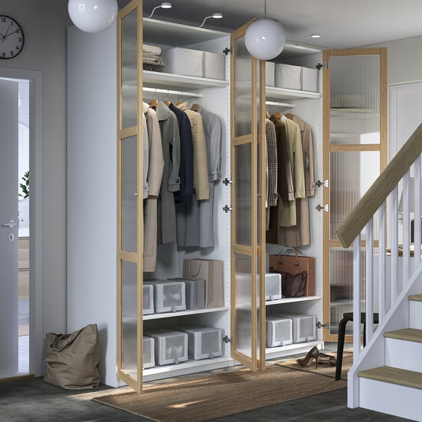 Armadio PAX: minimalista, con cappotti appesi, cestini, illuminazione, piedini regolabili e cerniere a chiusura ammortizzata.