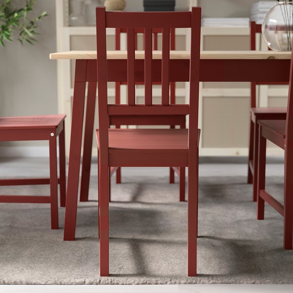 Sedia in legno rosso con schienale a doghe per cene in stile tradizionale.