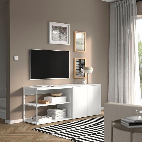 Soggiorno moderno con mobile contenitore PLATSA bianco, tv, foto, decorazioni, su tappeto a righe vicino alla finestra.