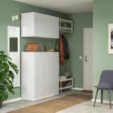 Ingresso moderno: pareti verdi, contenitore PLATSA, sedia blu, pianta, tappeto.