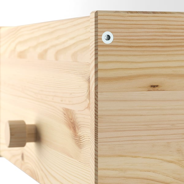 Primo piano degli appendiabiti in pino RAGGBERG liscio, finitura naturale e venature del legno di qualità.