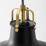 Lampada moderna con paralume nero, accenti in metallo dorato e snodi regolabili.