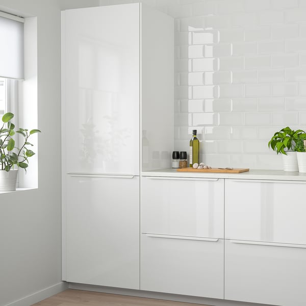 Cucina moderna bianca lucida. Contenitore alto; più grande delle piante in vaso.