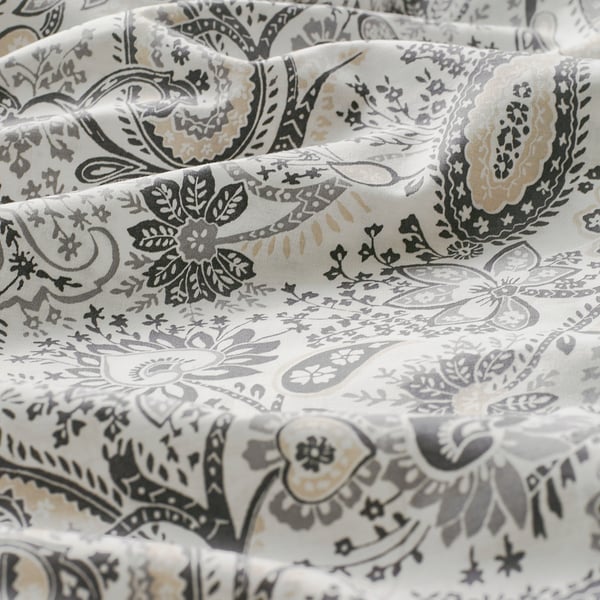 Federa paisley floreale, disegni intricati nei toni del nero, grigio e marrone su bianco, che mostrano una trama di tessuto pregiata.