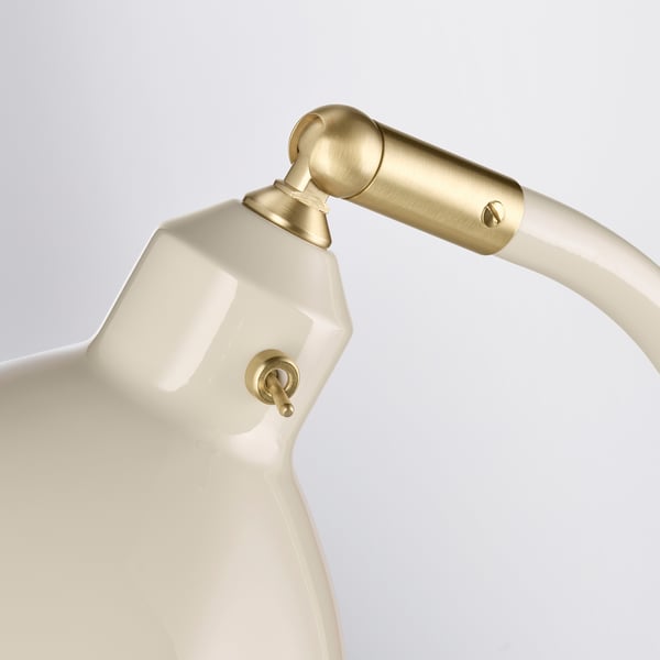 Lampada da scrivania bianca con accenti dorati con collo regolabile e interruttore a levetta, che emana un design elegante e industriale.