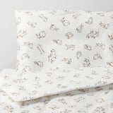 Copripiumino bianco con coniglietti marroni sparsi e abbozzati in pose giocose. Tessuto di cotone liscio e di alta qualità.