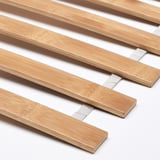 Primo piano di doghe in legno su un telaio del letto robusto e ben realizzato.